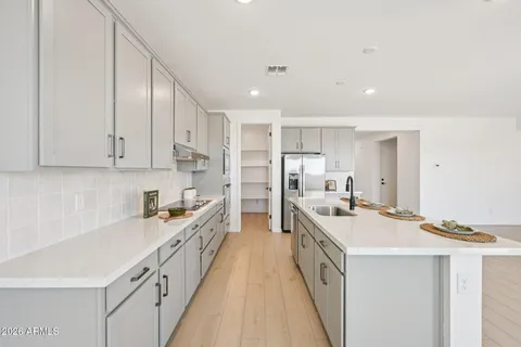 a kitchen that has a lot of cabinets in it and wooden floors