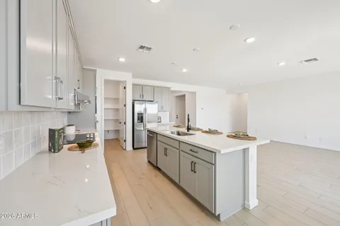 a kitchen with stainless steel appliances granite countertop a sink dishwasher stove and white cabinets with wooden floor