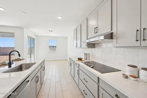 a large white kitchen with a stove and a sink