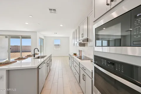 a kitchen with refrigerator a stove a sink and cabinets