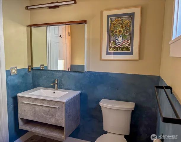 a bathroom with a sink mirror and toilet