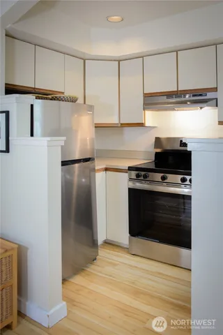 a kitchen with kitchen island granite countertop a refrigerator and a stove