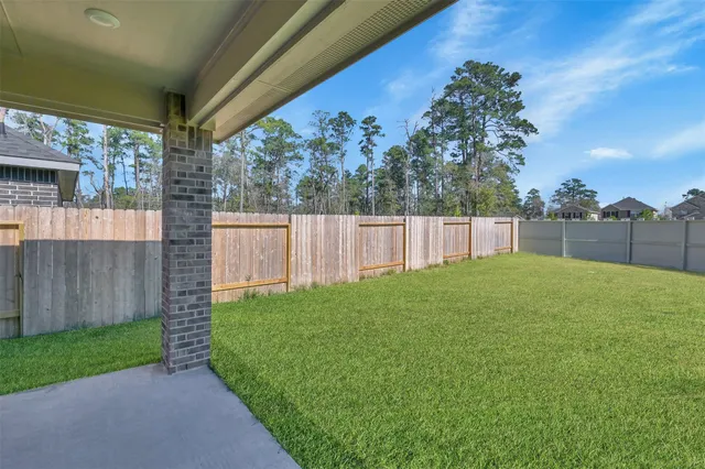 a view of a backyard with grass and fence