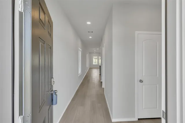 a view of a hallway with wooden floor