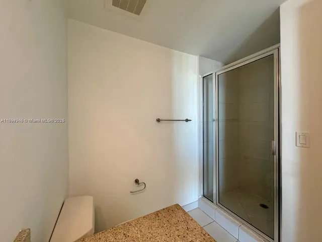a bathroom with a granite countertop sink toilet and mirror