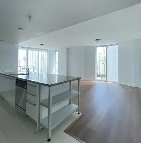 a kitchen with kitchen island a sink stainless steel appliances and cabinets