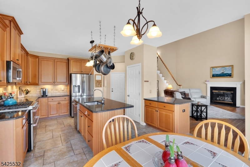 6 Ridge Road Frenchtown, NJ 08825 - Photo 11 of 33 a kitchen with stainless steel appliances granite countertop a sink a stove top oven a dining table and chairs with wooden floor