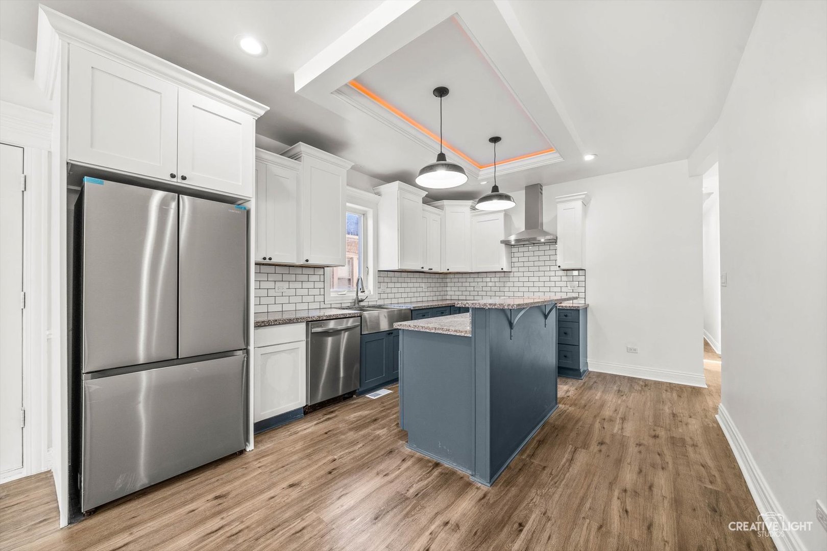 7724 South Chappel Avenue Chicago, IL 60649 - Photo 6 of 22 a kitchen with granite countertop a refrigerator a sink dishwasher a stove and white cabinets with wooden floor