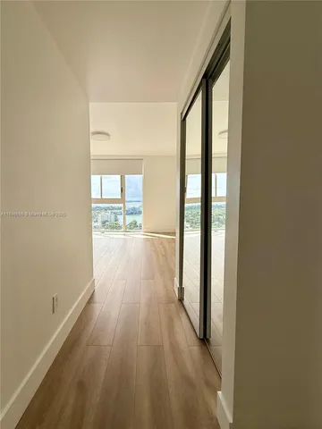 a view of a room with wooden floor and windows
