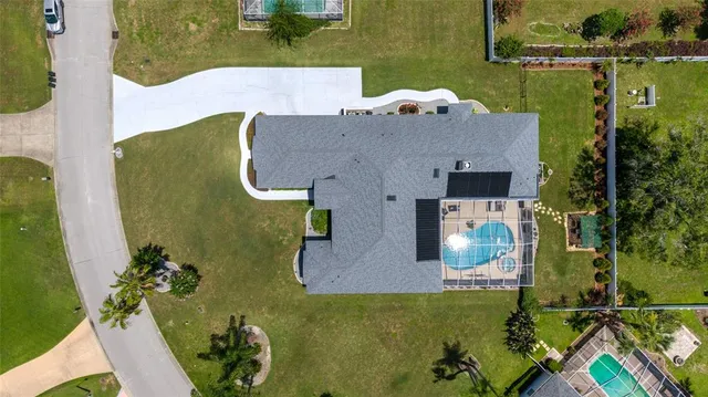 a aerial view of a house with table and chairs under an umbrella
