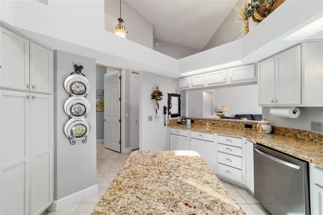a kitchen with kitchen island granite countertop a sink stove and cabinets