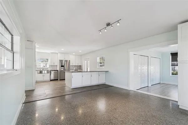 a view of a kitchen with refrigerator and windows