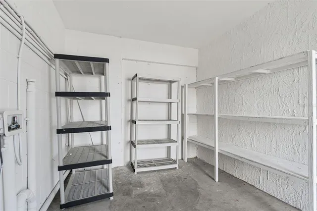 a view of an empty room with cabinet and mirrors