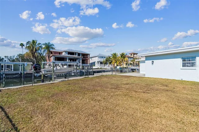a swimming pool with outdoor seating and yard in the back