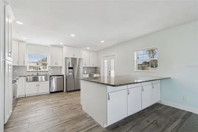 a kitchen with stainless steel appliances granite countertop a sink and cabinets
