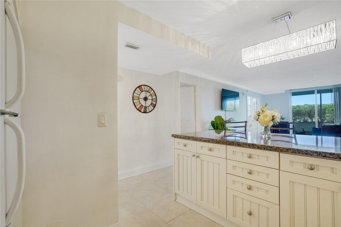5500 Northwest 2nd Avenue, Unit 119 Boca Raton, FL 33487 - Photo 3 of 22 a living room with white cabinets and clock on the wall