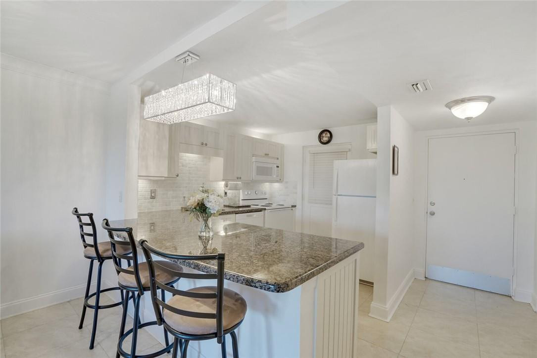 5500 Northwest 2nd Avenue, Unit 119 Boca Raton, FL 33487 - Photo 4 of 22 a kitchen with a table and chairs in it