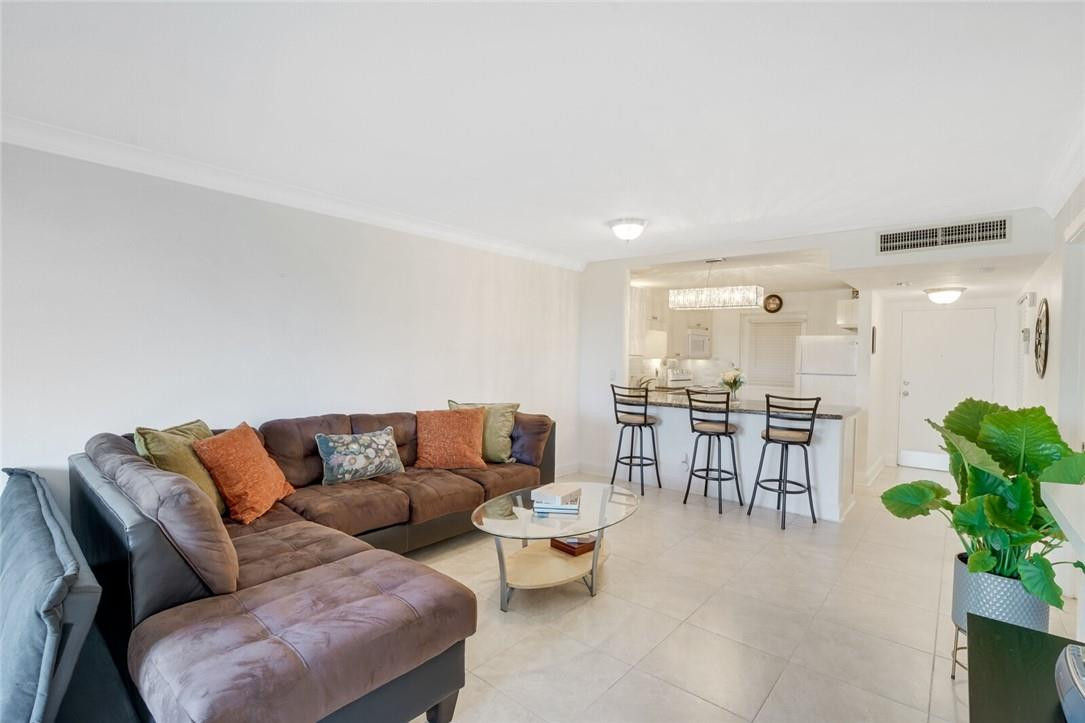 5500 Northwest 2nd Avenue, Unit 119 Boca Raton, FL 33487 - Photo 7 of 22 a living room with furniture and a dining table with kitchen view