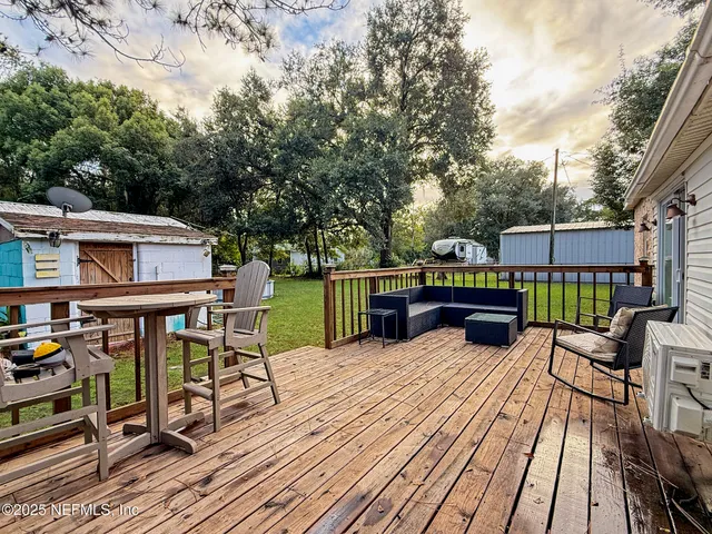 a view of a deck with table and chairs a barbeque with wooden floor and fence