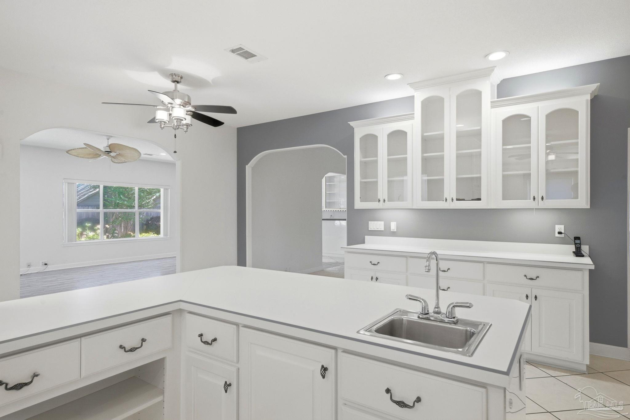 4552 Peaden Road Pace, FL 32571 - Photo 23 of 38 a kitchen with a white cabinets and chandelier