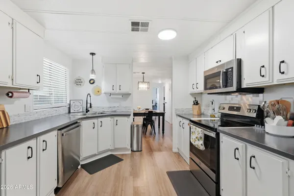 a kitchen with granite countertop cabinets stainless steel appliances a sink and wooden floor