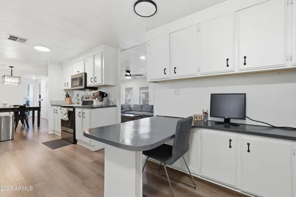a kitchen with granite countertop a table chairs stove and cabinets