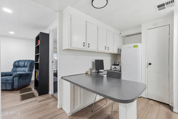 a kitchen with stainless steel appliances granite countertop a refrigerator a stove and white cabinets with wooden floor