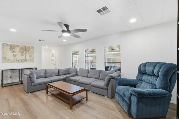 a living room with furniture ceiling fan and a large window