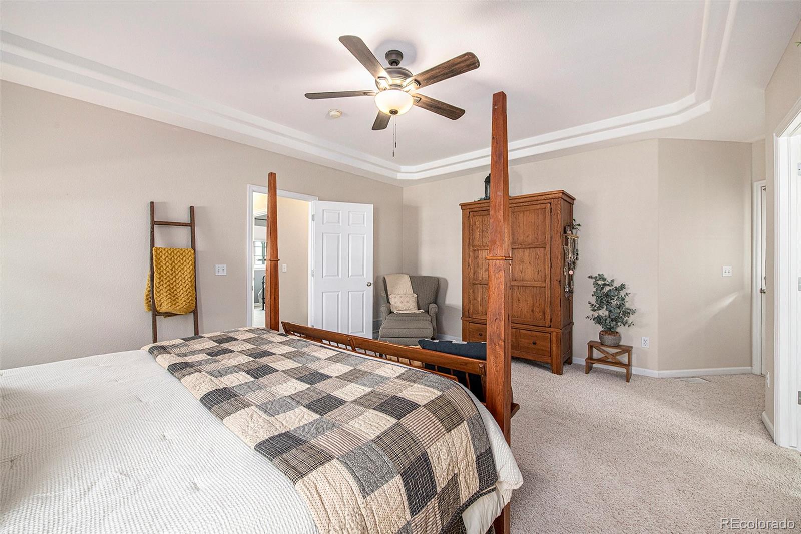320 Granite Way Johnstown, CO 80534 - Photo 13 of 39 a bedroom with a large bed and a chandelier