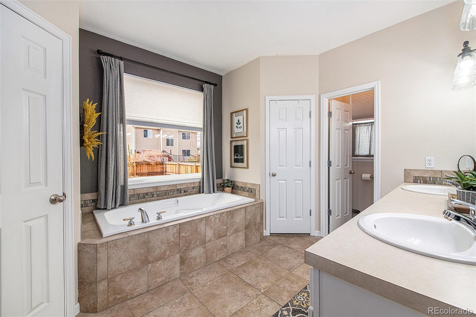 320 Granite Way Johnstown, CO 80534 - Photo 15 of 39 a bathroom with a tub sink and mirror