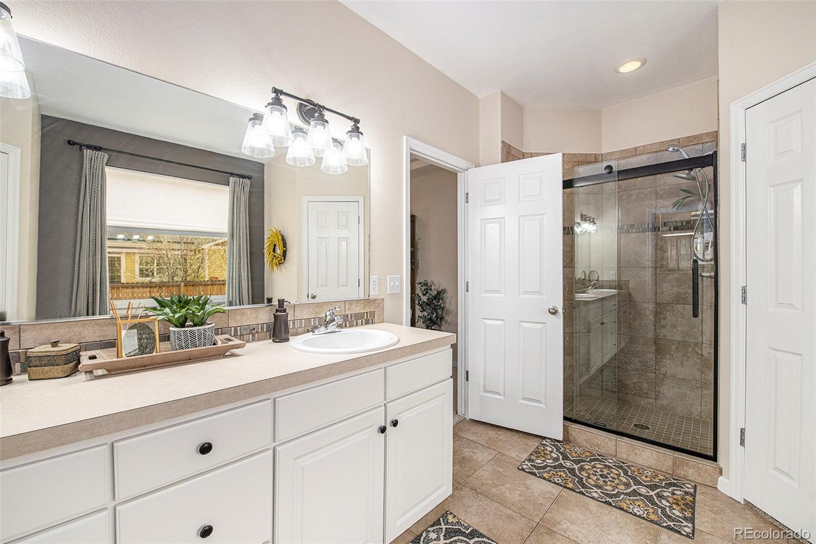 320 Granite Way Johnstown, CO 80534 - Photo 16 of 39 a bathroom with a double vanity sink mirror and shower