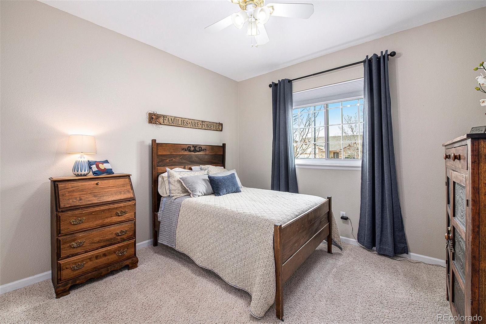 320 Granite Way Johnstown, CO 80534 - Photo 17 of 39 a bedroom with a bed and a chandelier