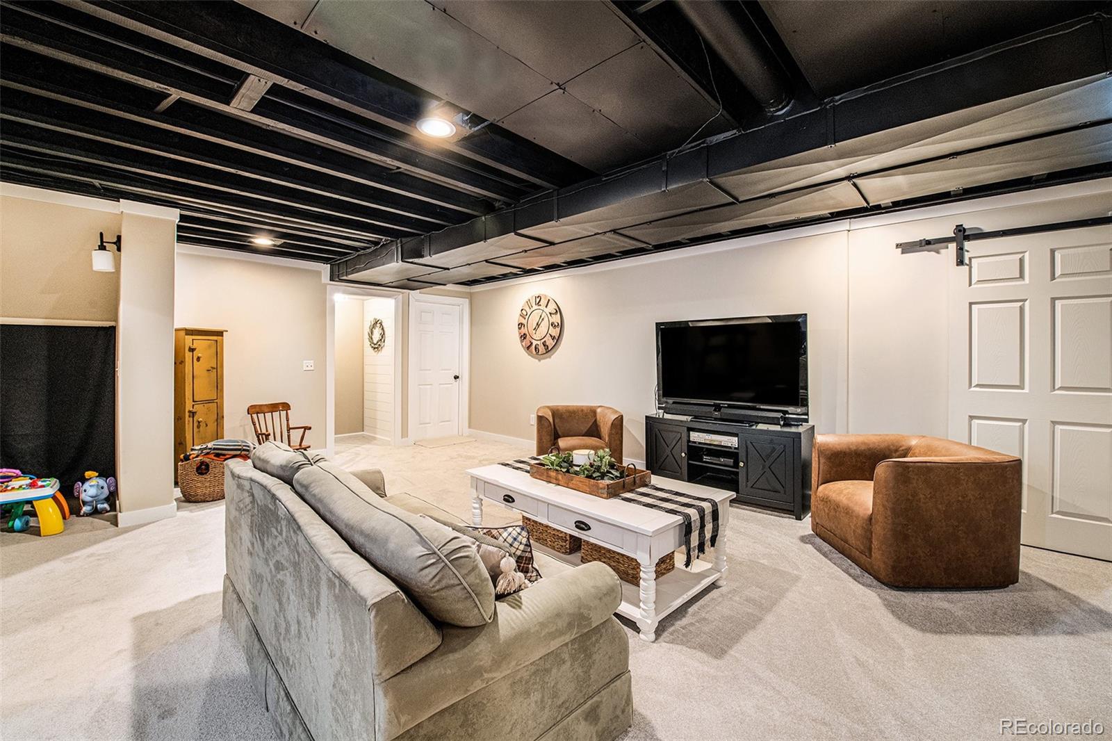 320 Granite Way Johnstown, CO 80534 - Photo 19 of 39 a living room with furniture and a flat screen tv