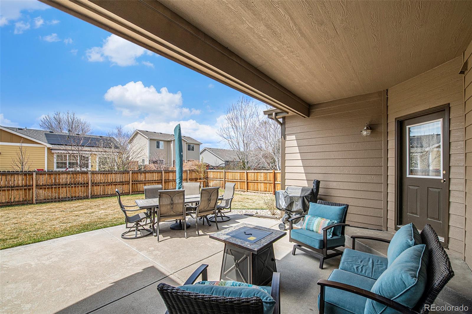 320 Granite Way Johnstown, CO 80534 - Photo 27 of 39 a view of a patio with dining table and chairs with couches and potted plants