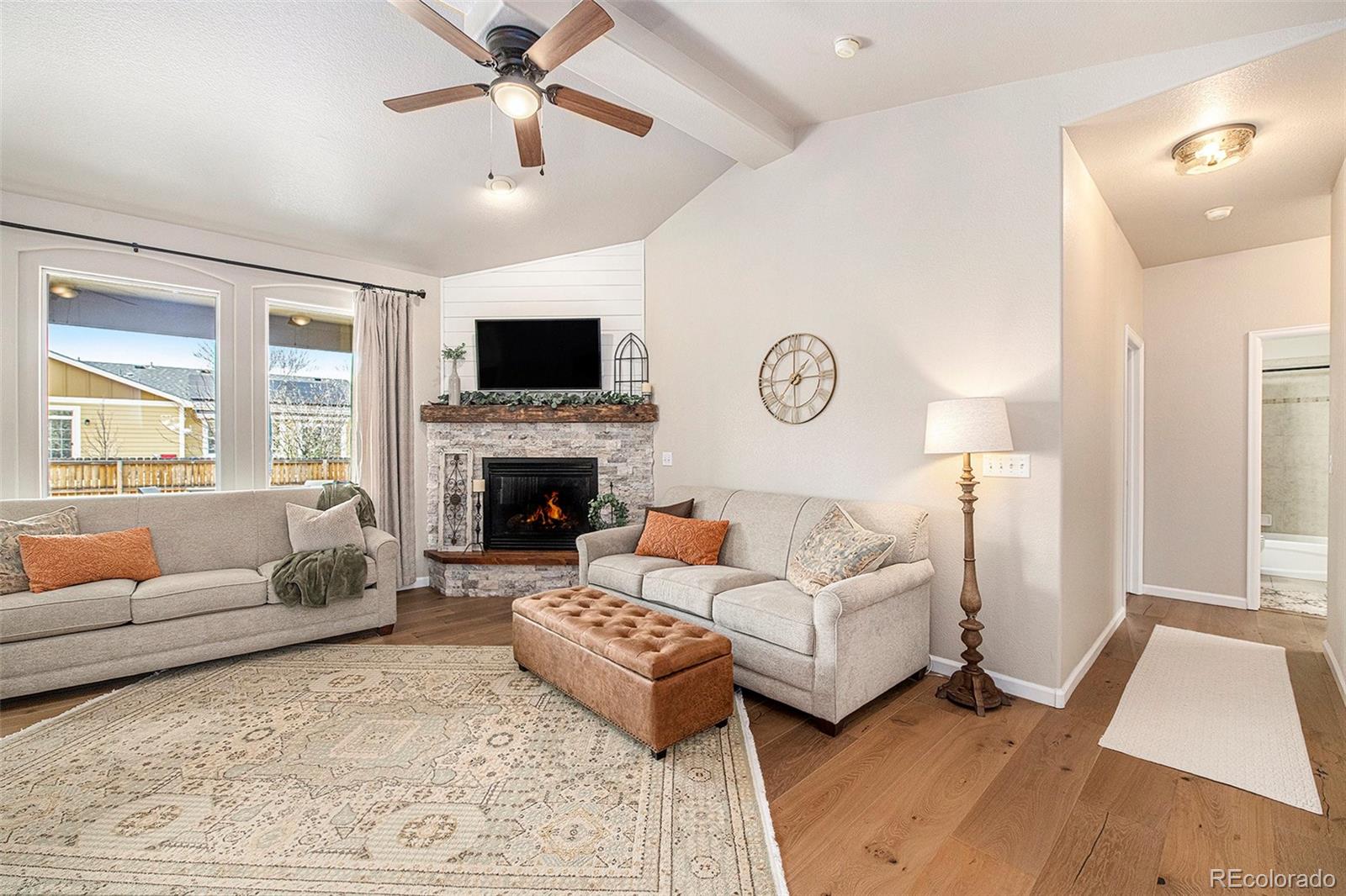 320 Granite Way Johnstown, CO 80534 - Photo 3 of 39 a living room with furniture a flat screen tv and a fireplace