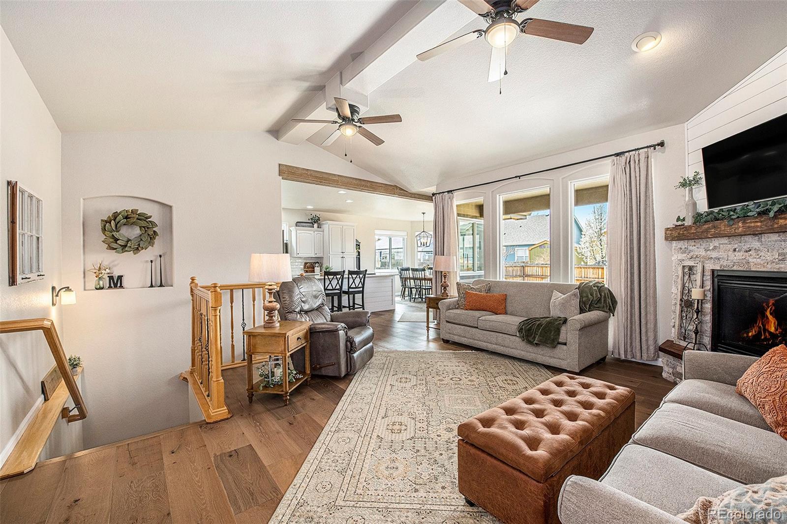 320 Granite Way Johnstown, CO 80534 - Photo 4 of 39 a living room with furniture a flat screen tv and a fireplace