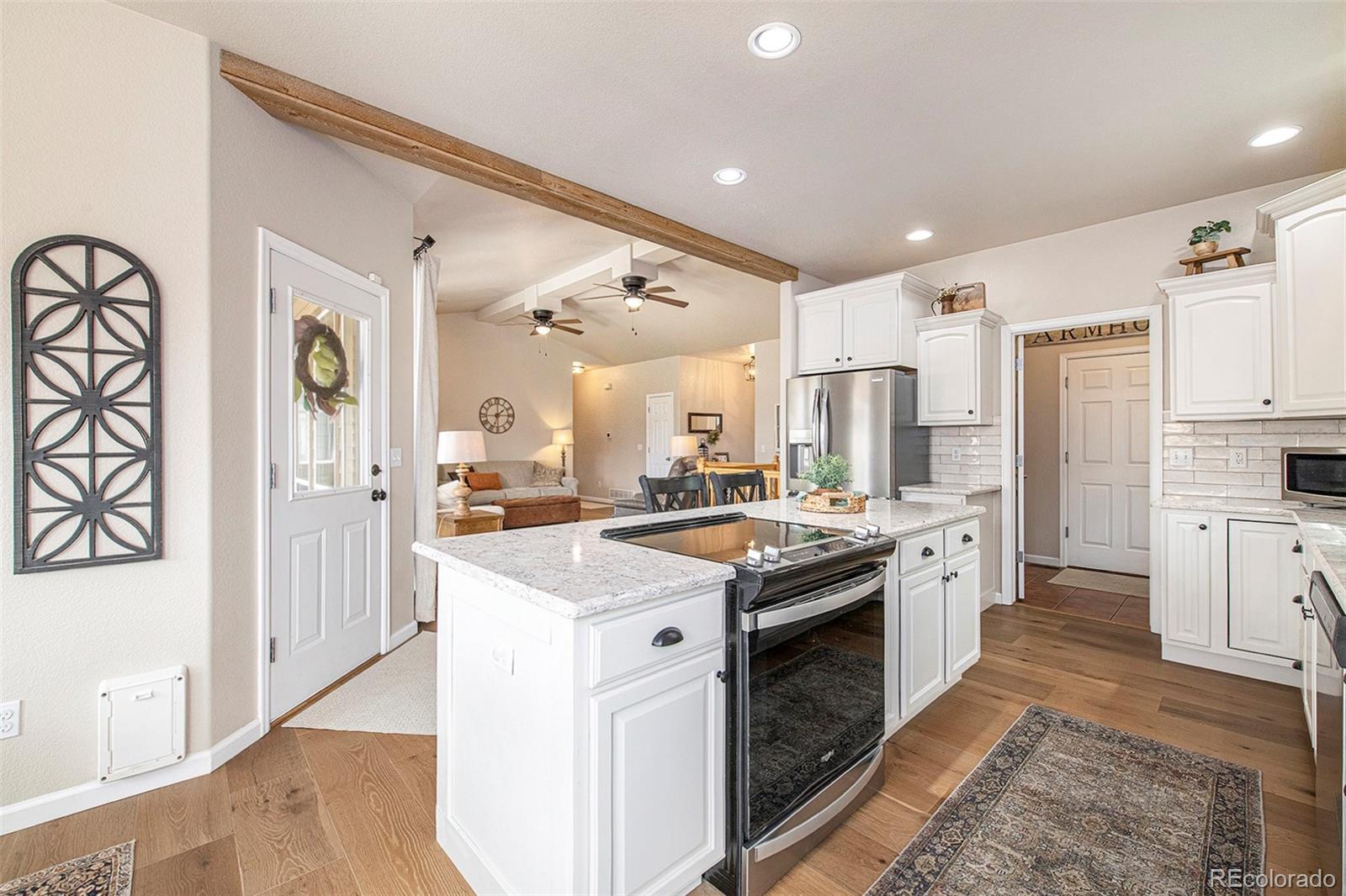 320 Granite Way Johnstown, CO 80534 - Photo 7 of 39 a kitchen with granite countertop a sink stove and refrigerator