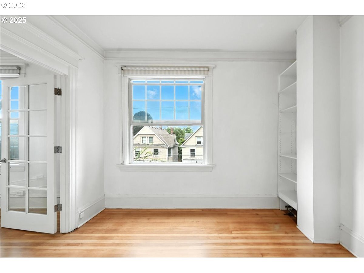 2109 Northwest Irving Street, Unit 304 Portland, OR 97210 - Photo 11 of 25 a view of an empty room with wooden floor and a window