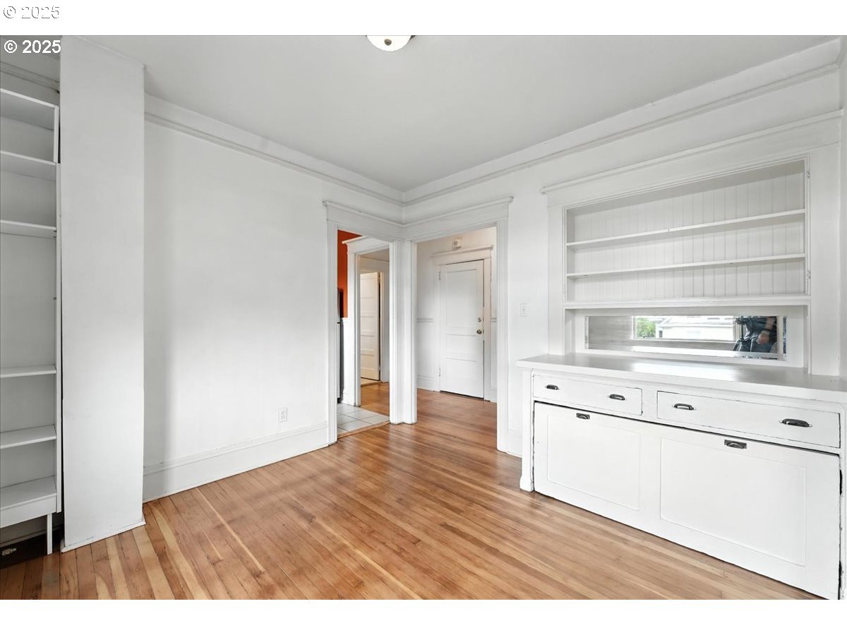 2109 Northwest Irving Street, Unit 304 Portland, OR 97210 - Photo 12 of 25 a kitchen with cabinets wooden floor and a window