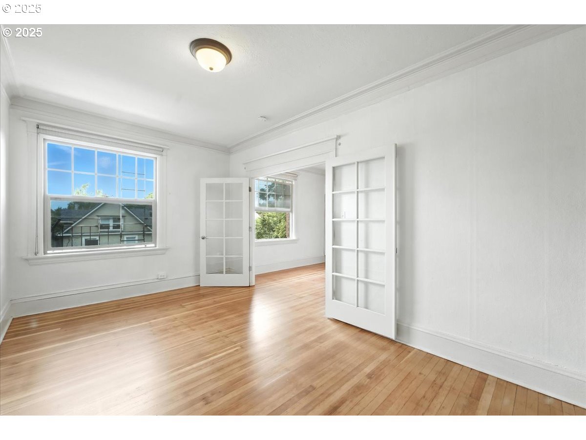 2109 Northwest Irving Street, Unit 304 Portland, OR 97210 - Photo 16 of 25 a view of an empty room with wooden floor and a window