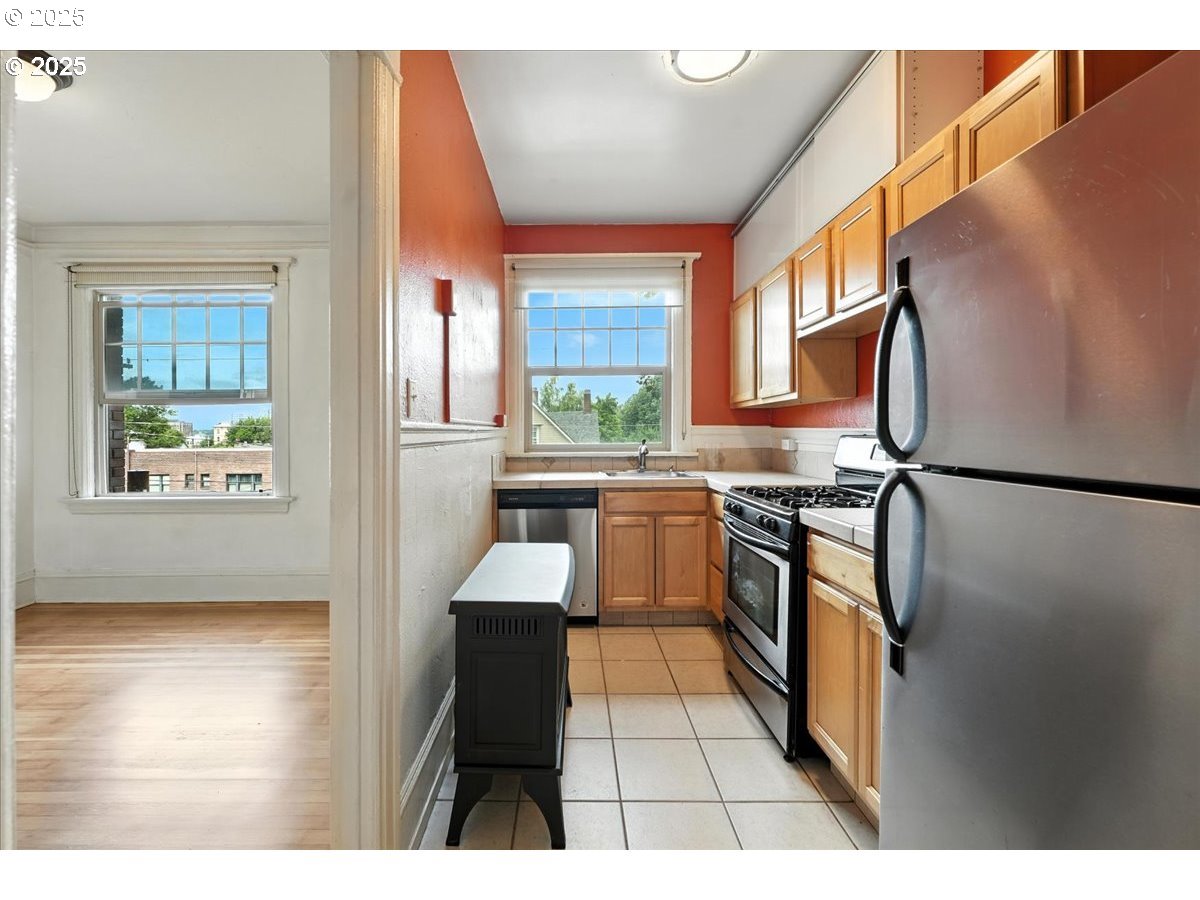 2109 Northwest Irving Street, Unit 304 Portland, OR 97210 - Photo 20 of 25 a kitchen with stainless steel appliances granite countertop a refrigerator and a sink