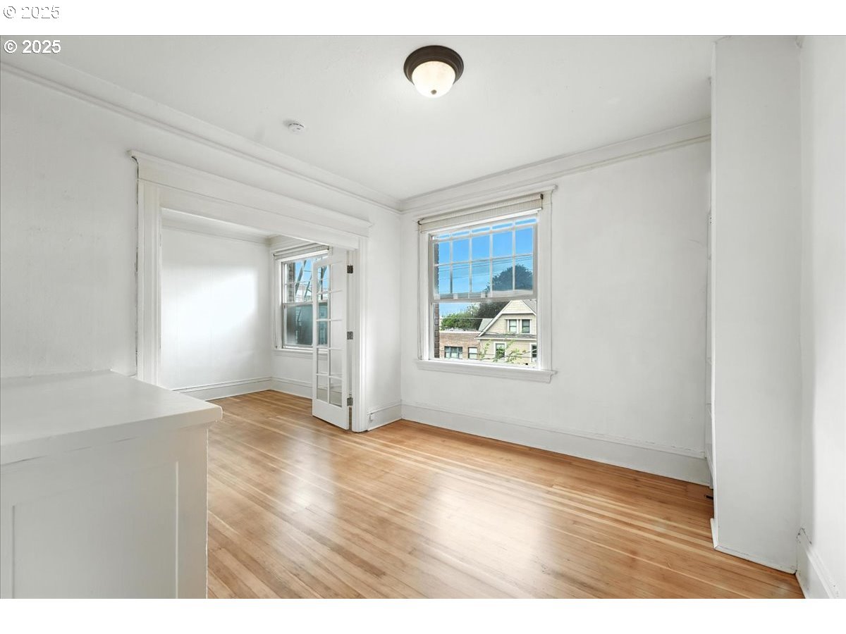 2109 Northwest Irving Street, Unit 304 Portland, OR 97210 - Photo 9 of 25 a view of an empty room with window and wooden floor