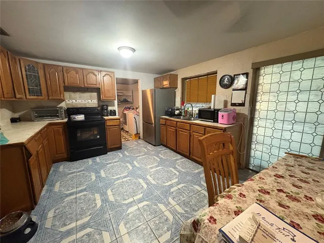 a kitchen with stainless steel appliances kitchen island granite countertop a sink stove and refrigerator
