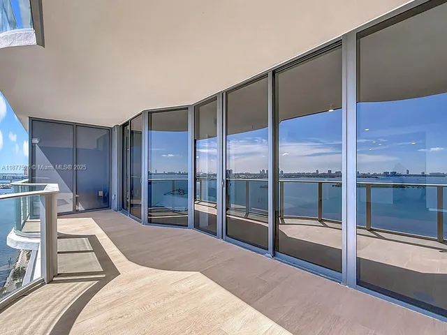 a view of a hallway with wooden floor cabinets and a bathroom