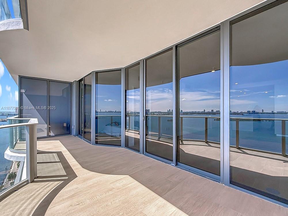 700 Northeast 24th Street, Unit 1402 Miami, FL 33137 - Photo 22 of 68 a spacious bedroom with a large window and a balcony