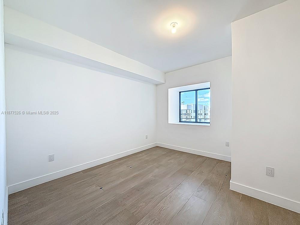 700 Northeast 24th Street, Unit 1402 Miami, FL 33137 - Photo 23 of 68 an empty room with wooden floor and windows