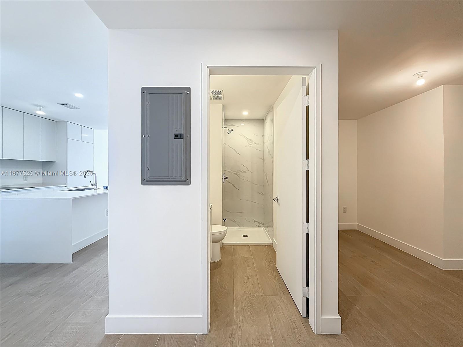 700 Northeast 24th Street, Unit 1402 Miami, FL 33137 - Photo 28 of 68 a view of a hallway with wooden floor cabinets and a bathroom