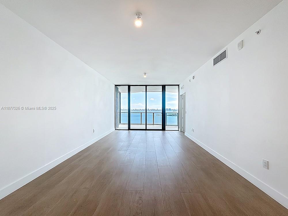 700 Northeast 24th Street, Unit 1402 Miami, FL 33137 - Photo 4 of 68 wooden floor in an empty room with a window