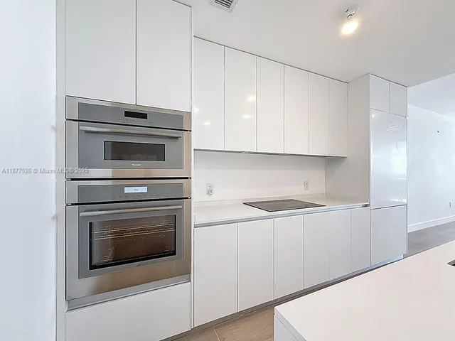 a view of a hallway with a sink and a mirror