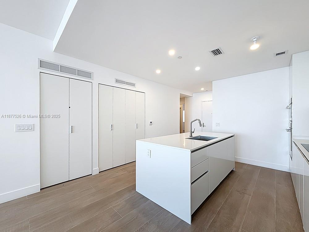 700 Northeast 24th Street, Unit 1402 Miami, FL 33137 - Photo 9 of 68 a view of a hallway with a sink and a mirror